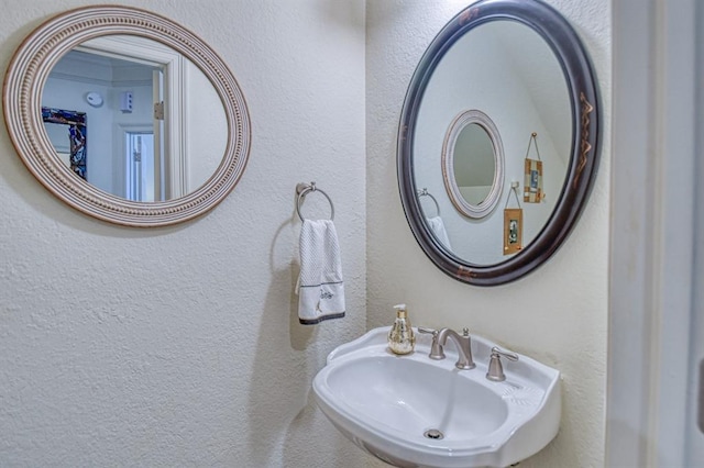 bathroom with a textured wall and a sink