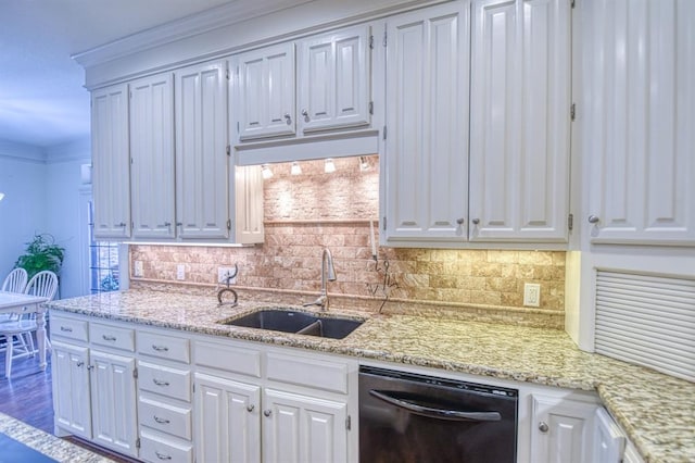 kitchen with tasteful backsplash, white cabinets, dishwasher, and a sink