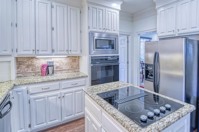 kitchen with a kitchen island, decorative backsplash, black appliances, white cabinets, and crown molding