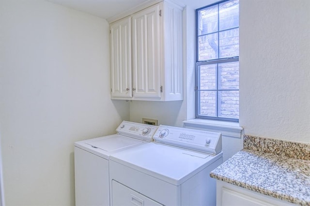 laundry area with washer and clothes dryer, cabinet space, and a healthy amount of sunlight