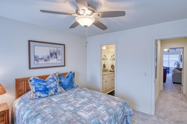 bedroom with a ceiling fan, light colored carpet, baseboards, and ensuite bathroom