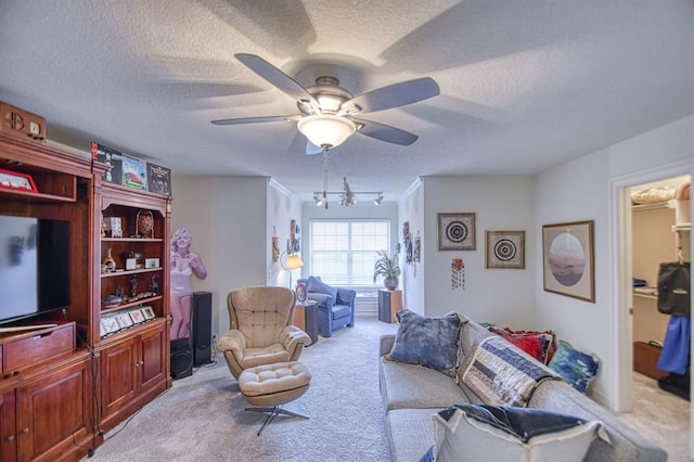 carpeted living area with a textured ceiling and ceiling fan