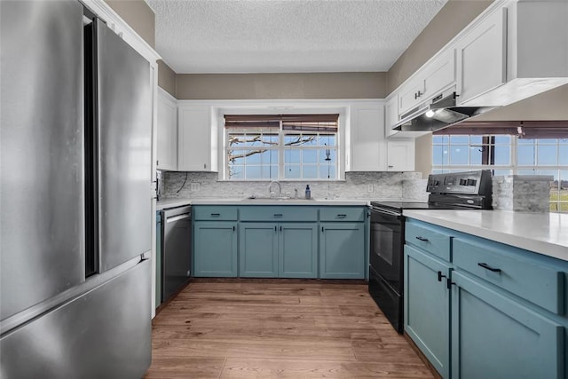 kitchen featuring light wood-style flooring, white cabinets, appliances with stainless steel finishes, and a sink