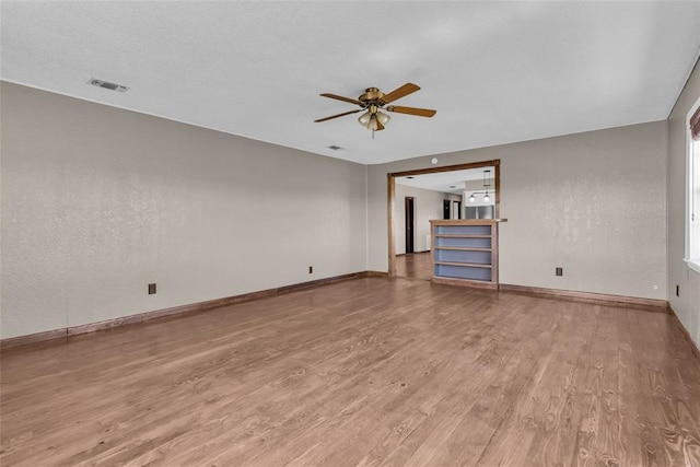 unfurnished living room with visible vents, ceiling fan, baseboards, and light wood-style floors