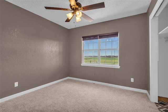 spare room with baseboards, a textured ceiling, ceiling fan, and carpet