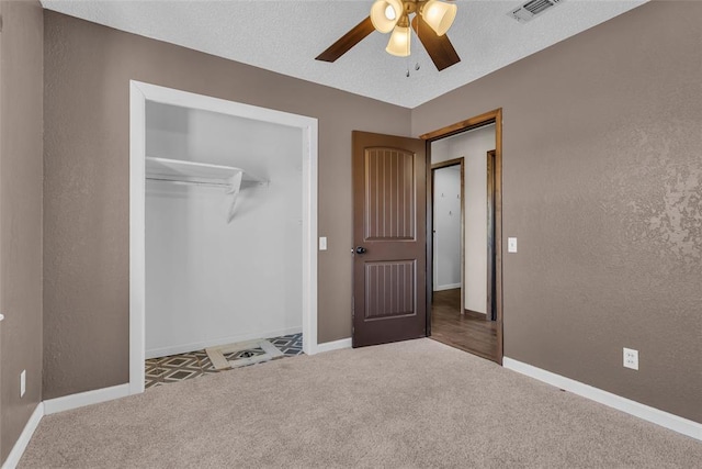 unfurnished bedroom with visible vents, baseboards, carpet flooring, and a textured wall