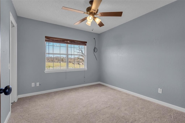 empty room featuring baseboards, a textured ceiling, and carpet flooring