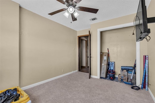 bedroom featuring baseboards, visible vents, carpet floors, ceiling fan, and a textured ceiling