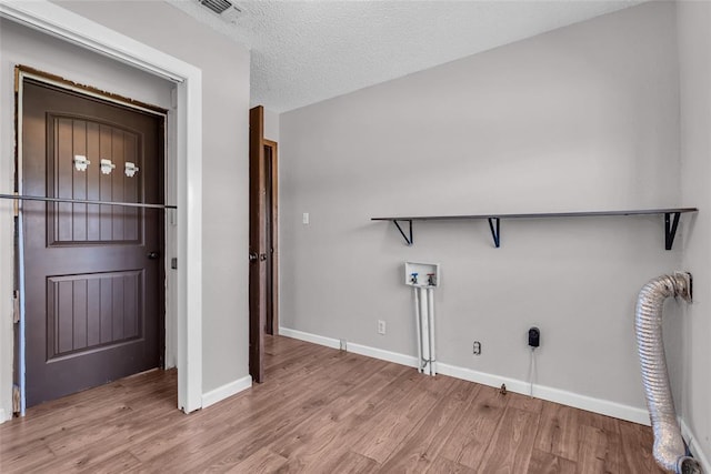 laundry room with visible vents, baseboards, hookup for a washing machine, wood finished floors, and a textured ceiling