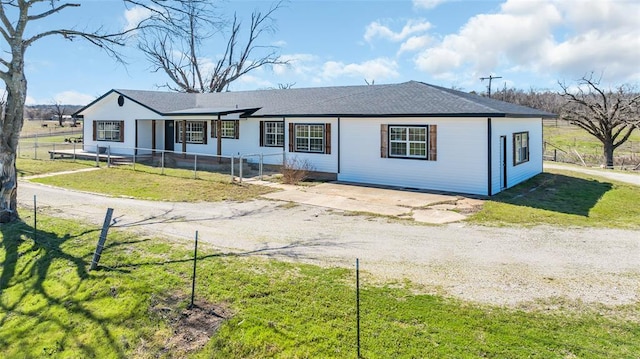 single story home featuring a front lawn, driveway, and fence