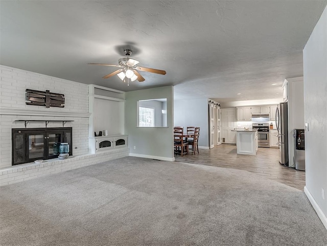 4303 N Redmond Ave, Bethany, OK 73008 - living room featuring light carpet, ceiling fan, and a fireplace