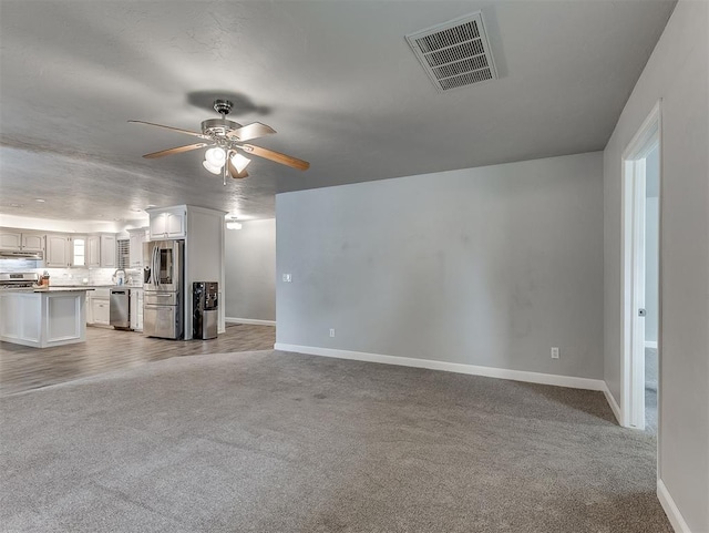 4303 N Redmond Ave, Bethany, OK 73008 - unfurnished living room featuring light colored carpet and ceiling fan