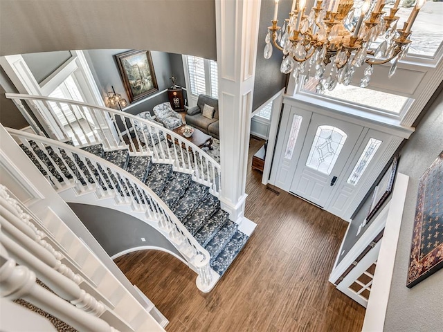 entrance foyer featuring visible vents, a chandelier, stairway, a high ceiling, and wood finished floors