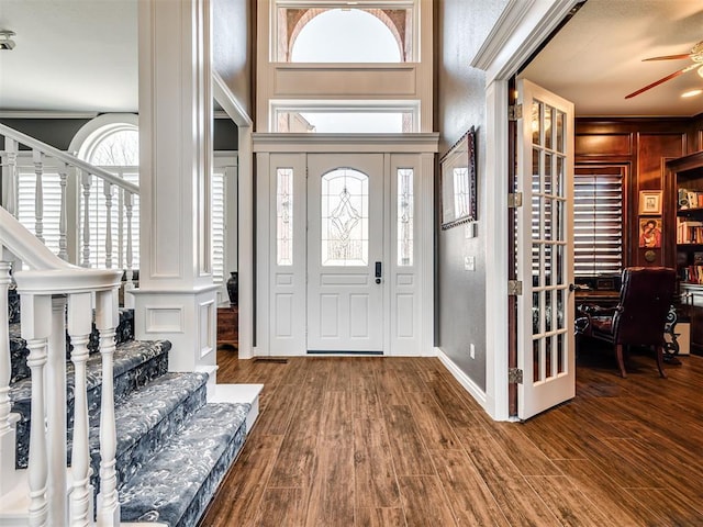 foyer entrance featuring a ceiling fan, stairway, wood finished floors, and baseboards