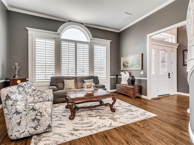 living area featuring baseboards, wood finished floors, and crown molding