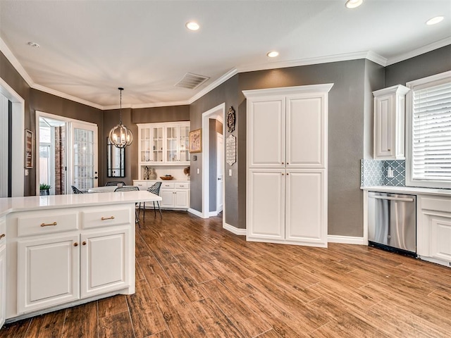 kitchen with a notable chandelier, stainless steel dishwasher, wood finished floors, and white cabinetry