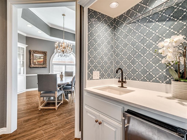 interior space with crown molding, recessed lighting, stainless steel dishwasher, wood finished floors, and a sink