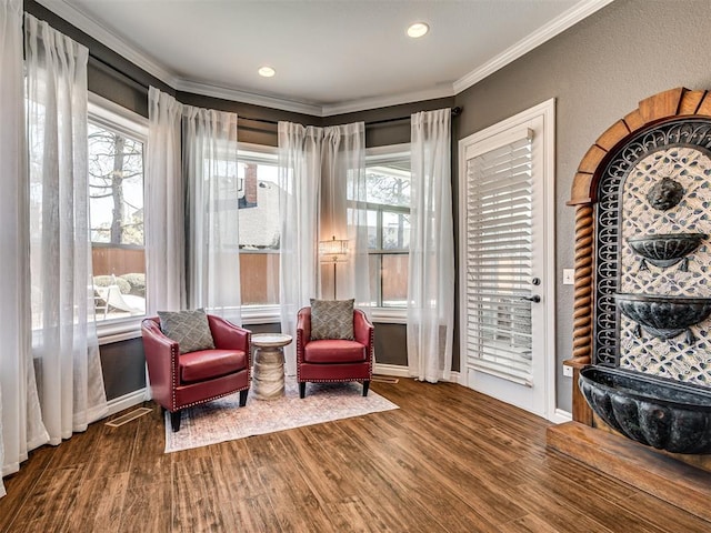 living area featuring crown molding, plenty of natural light, wood finished floors, and baseboards