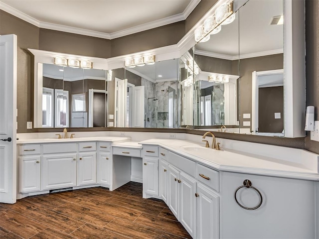 bathroom featuring crown molding, wood finished floors, and a sink