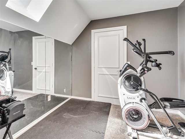 exercise room featuring vaulted ceiling and baseboards