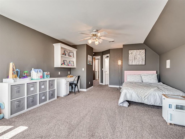 bedroom with visible vents, built in desk, baseboards, lofted ceiling, and light colored carpet