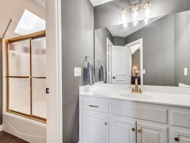 full bath with vanity, visible vents, and bath / shower combo with glass door