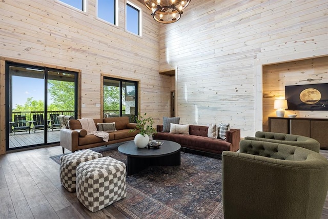 living area featuring a chandelier, wood walls, and wood finished floors