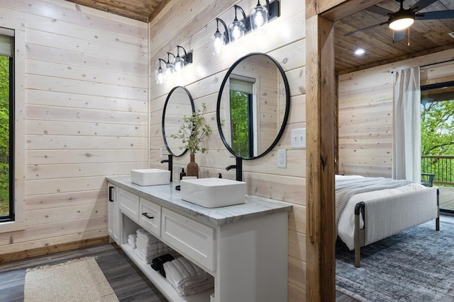 bathroom featuring a sink, wood finished floors, wood ceiling, and wood walls