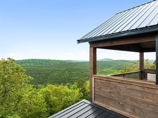 wooden terrace featuring a view of trees