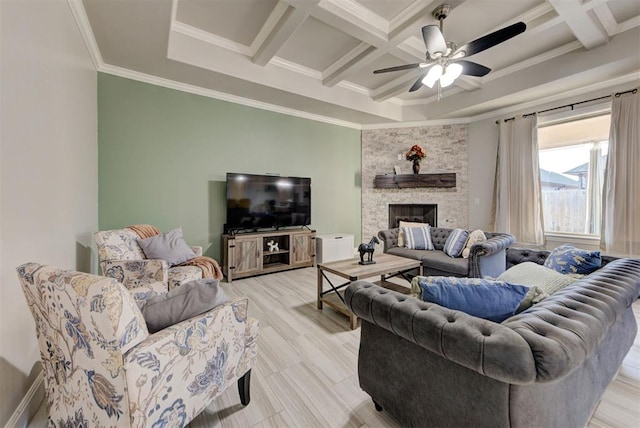 living room featuring coffered ceiling, beam ceiling, ceiling fan, a stone fireplace, and crown molding