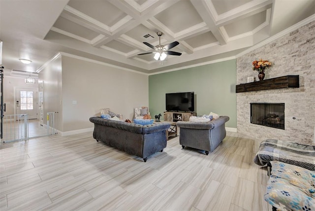 living room featuring visible vents, crown molding, beam ceiling, a stone fireplace, and coffered ceiling