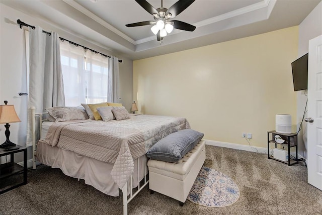 carpeted bedroom featuring ceiling fan, a raised ceiling, baseboards, and ornamental molding