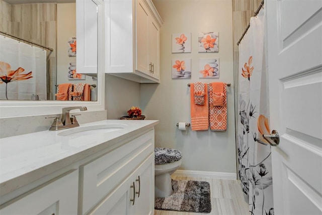 bathroom featuring vanity, curtained shower, toilet, and baseboards