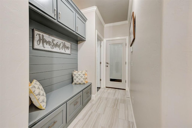 mudroom with crown molding and baseboards