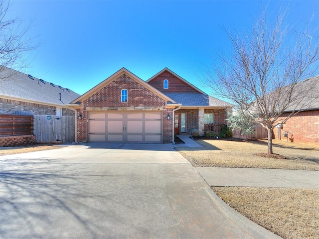 view of front of property with concrete driveway, a garage, fence, and brick siding