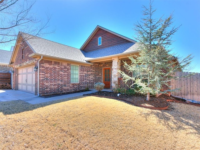 view of front of house with brick siding, roof with shingles, a garage, and fence