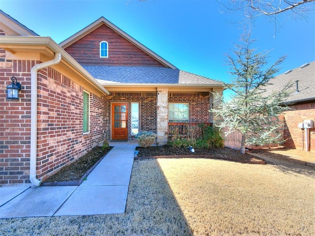 property entrance with brick siding and a shingled roof