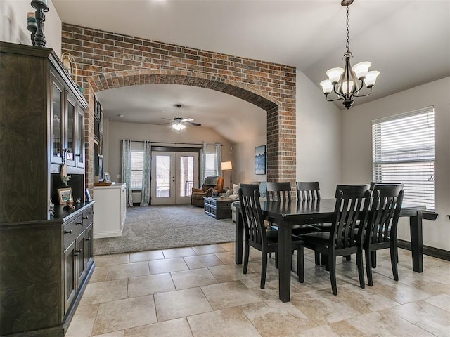 dining area featuring brick wall, vaulted ceiling, light carpet, french doors, and arched walkways