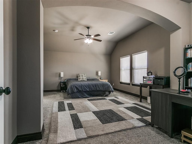 bedroom with visible vents, lofted ceiling, arched walkways, carpet floors, and baseboards