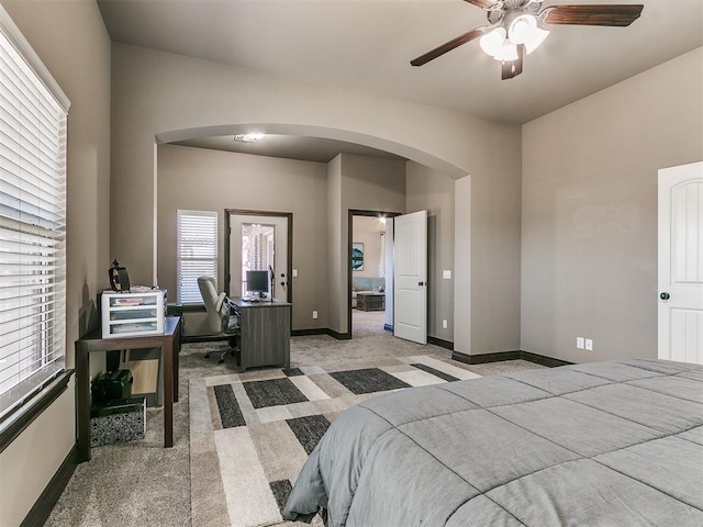 bedroom with light colored carpet, baseboards, and arched walkways