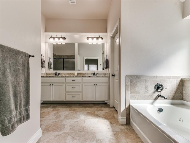 bathroom featuring double vanity, a jetted tub, a shower stall, and a sink