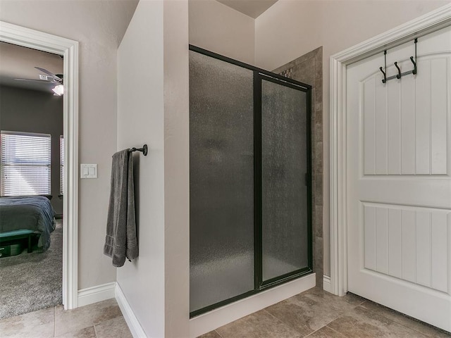 ensuite bathroom featuring tile patterned flooring, a stall shower, ensuite bath, and baseboards