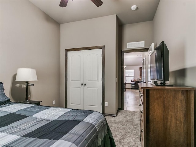 bedroom with light colored carpet, visible vents, and a closet