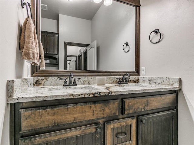 full bath with double vanity, visible vents, and a sink