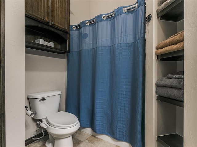 bathroom with toilet and a shower with shower curtain