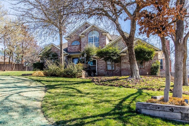 view of front of house featuring brick siding and a front yard