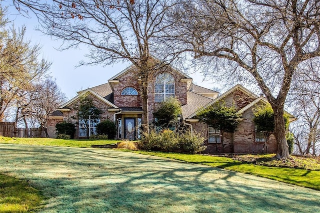 view of front facade with a front yard and brick siding