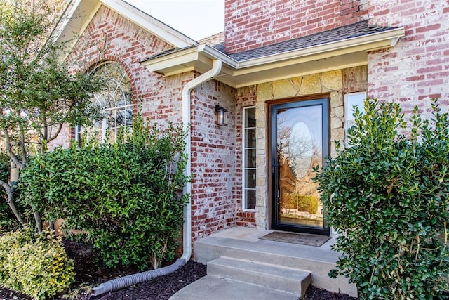 view of exterior entry with brick siding