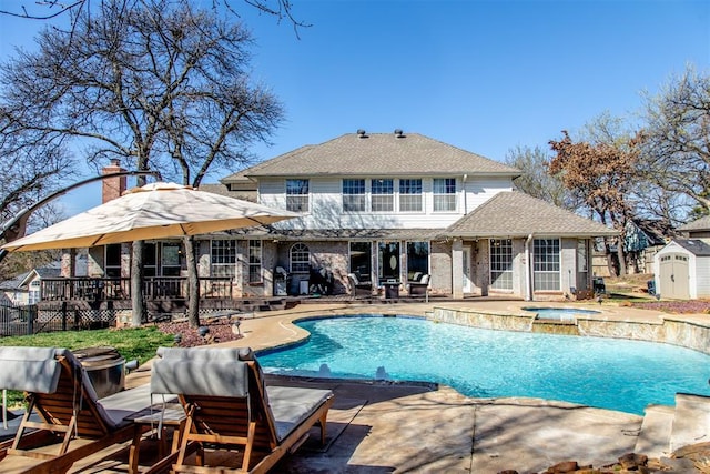 view of swimming pool with a fenced in pool, a storage shed, an outbuilding, an in ground hot tub, and a patio