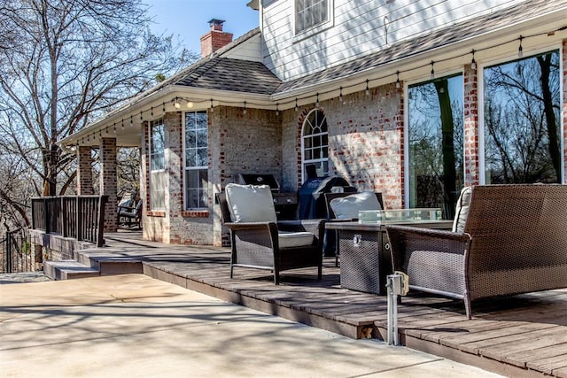 view of patio with area for grilling and a wooden deck